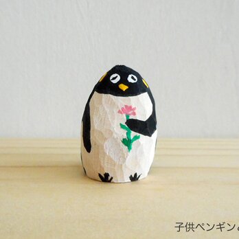 6月から値上げをします　木彫り　子供ペンギン　花をもつ47の画像