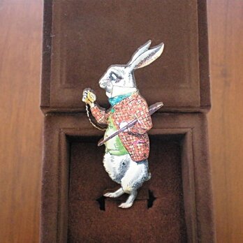 時計を見つめるウサギのブローチの画像