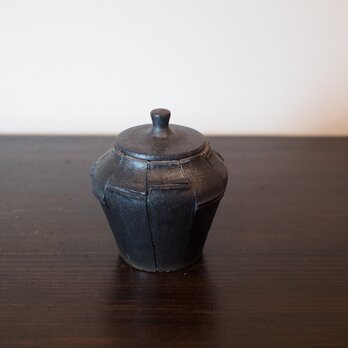 竹炭を細工し、蓋物にしたような陶器の蓋物。
