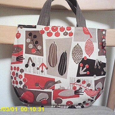 オックスベージュ地に４色使い柄のまる底手提げ