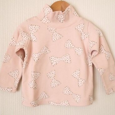 ピンクのリボン柄のタートルネックカットソー (100cm)