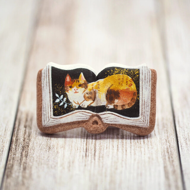 絵本ブローチ《三毛猫ミーコ》【手描きイラスト・陶器・陶土ブローチ】の画像1枚目