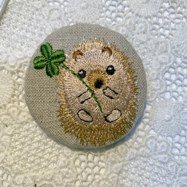 四葉のクローバーとハリネズミ 刺繍のブローチ 丸 リネン 50ミリの画像1枚目