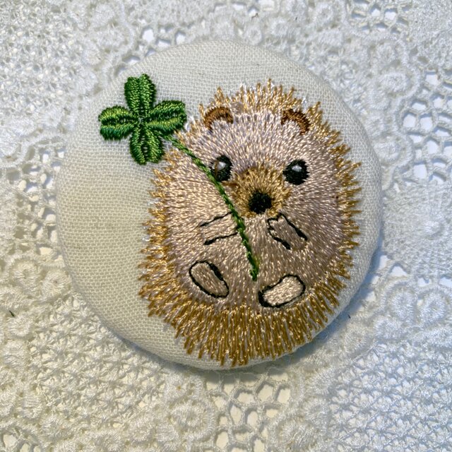 四葉のクローバーとハリネズミ 刺繍のブローチ 丸 エクリュ 50ミリの画像1枚目