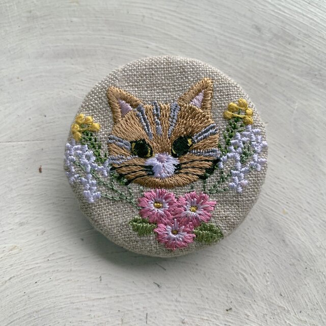 猫のトラちゃんと小花 刺繍のブローチ 丸 リネン 50ミリの画像1枚目