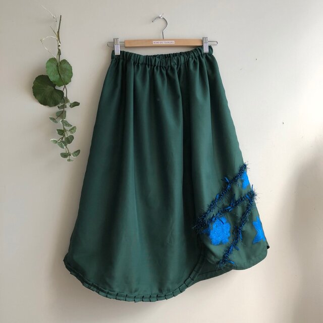 深いグリーンの裾変形スカート