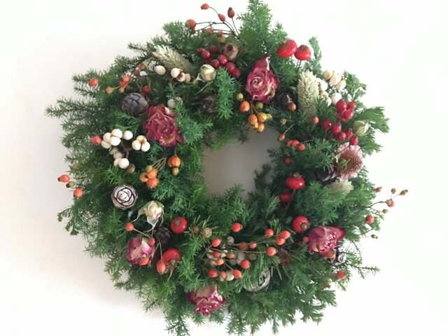 赤い実と赤いバラのクリスマスリースの画像1枚目