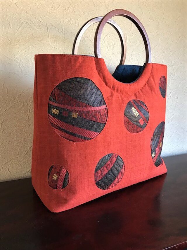 朱赤紬の帯地に幾何模様帯地の嵌め込み手提げ　丸い木の手