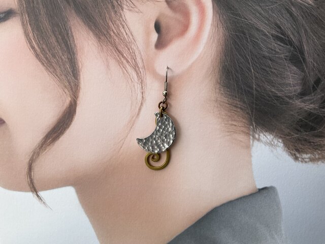 上弦の月と下弦の月を表現した槌目のトップに、真鍮で作ったチャームを