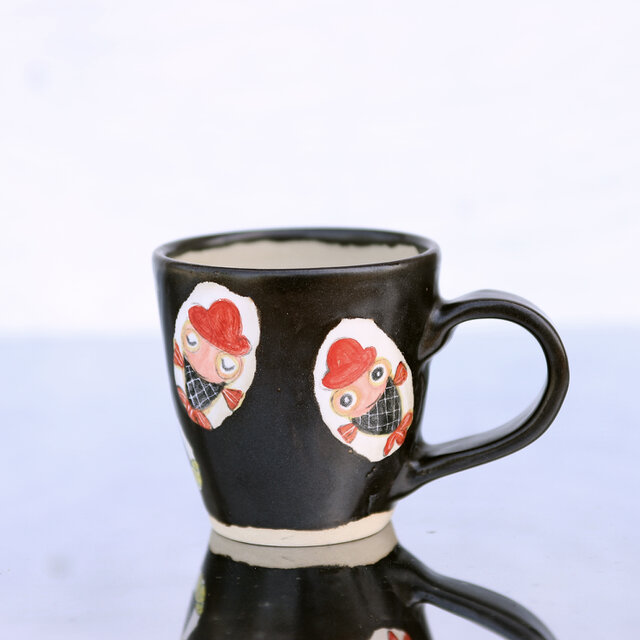 黒釉と赤い帽子をかぶった金魚絵のマグ