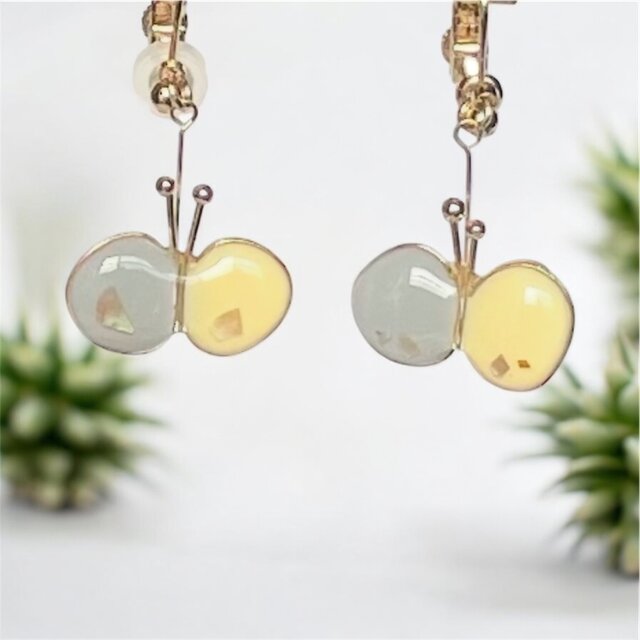 上品なグレーとクリームイエローのちょうちょが耳元でキラキラするピアス