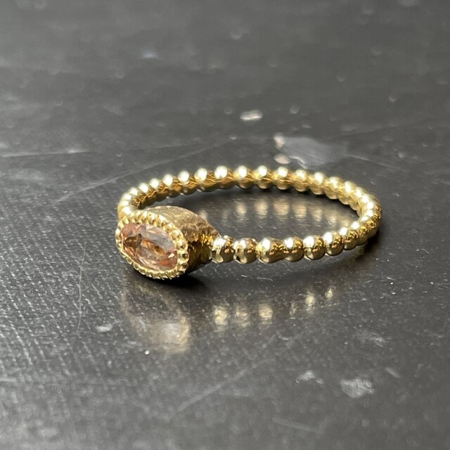 インペリアルトパーズ オーバルカット0.69ct ミル打ちと丸つぶ腕