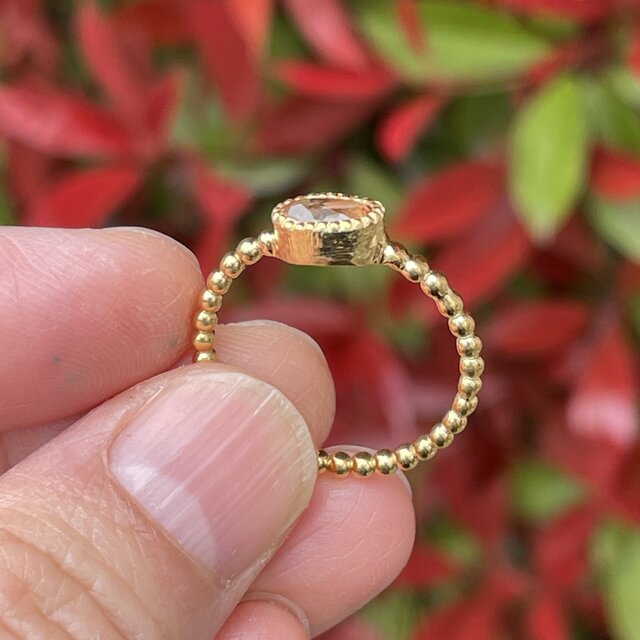 インペリアルトパーズ オーバルカット0.69ct ミル打ちと丸つぶ腕