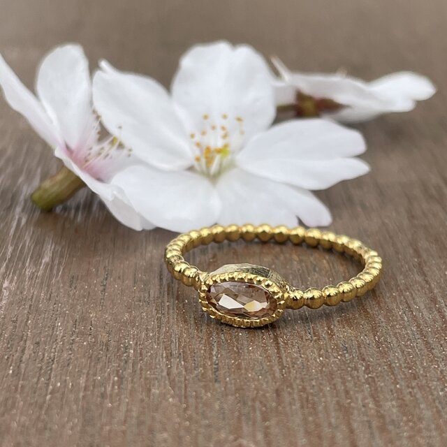 インペリアルトパーズ オーバルカット0.69ct ミル打ちと丸つぶ腕