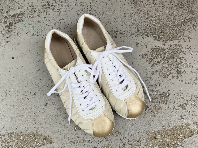 シャンパンゴールドが上品に輝くレザースニーカー｜大人カジュアルに