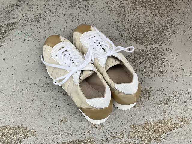 シャンパンゴールドが上品に輝くレザースニーカー｜大人カジュアルに