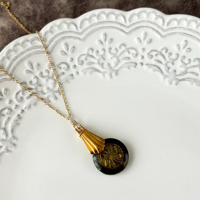 マドレーヌ型のパーツとボタンのネックレス　チェーンはサージカルステンレス