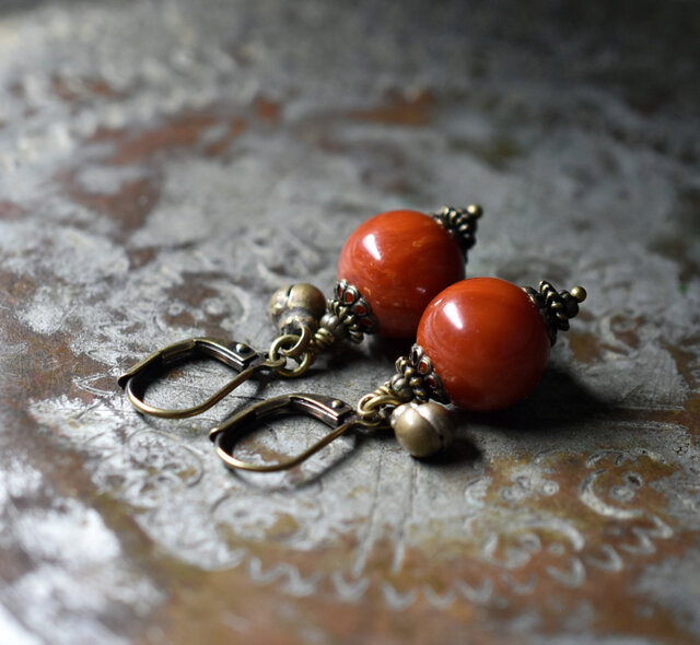 珊瑚色まん丸アフリカンアンバーと民族鈴のピアス(1.2mm) | iichi