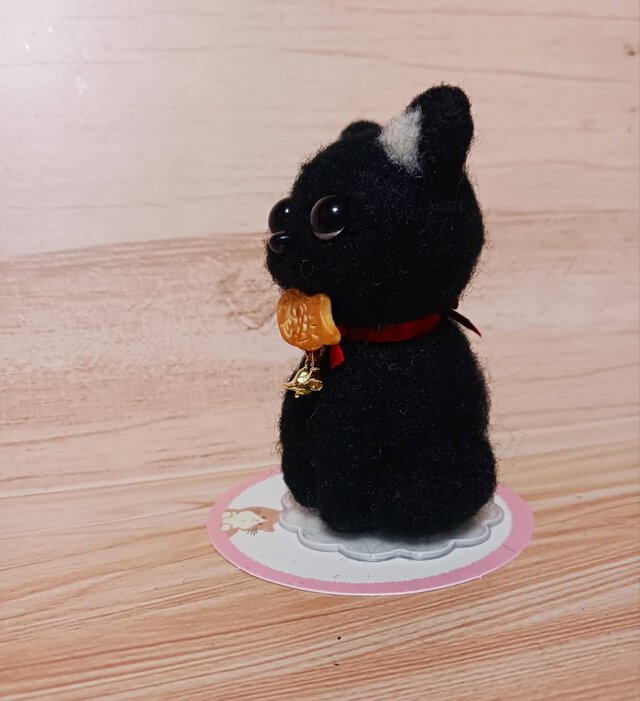小さくて目のクリクリの可愛い黒猫 口にくわえてるのタイ焼きだよ