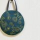 ボタニカル幾何学刺繍の丸いかばんの画像